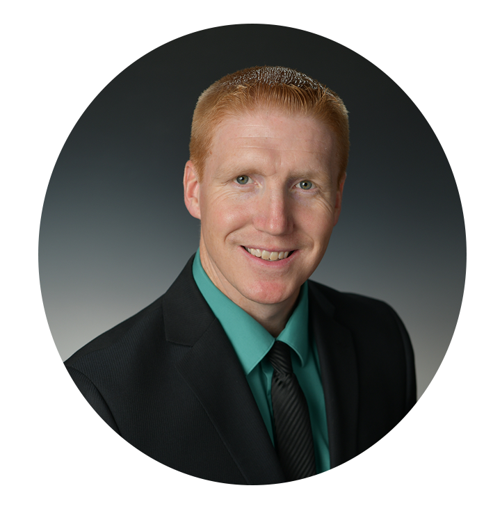 Headshot of Kentucky Farmers Bank AVP/ Loan Officer. He is smiling, wearing a suit with a green shirt and black tie against a grey background.